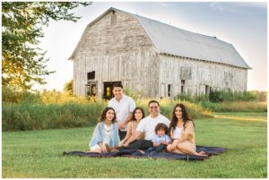 Family of six seated in front of Rustic Barn